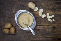 Pastinaca biologica e patate, alimenti per bambini in ciotola e cucchiaio su legno scuro — Foto stock