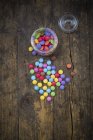 Smarties, candy jar and glass cover on wood — Stock Photo
