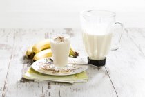 Стакан банан молочний коктейль з збиті вершки і шоколад гранули — стокове фото