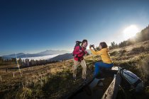 Austria, Altenmarkt-Zauchensee, young couple taking picture on hiking trip at Niedere Tauern — Stock Photo