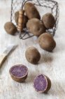 Batatas vermelhas inteiras e cortadas pela metade — Fotografia de Stock