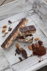 Barrette italiane di torrone, mandorla, nocciola, cacao in polvere, cioccolato su vassoio di legno — Foto stock