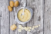 Pastinaca biologica e patate in ciotola con cucchiaio su legno vivo — Foto stock