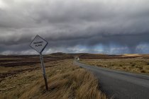 Reino Unido, Escocia, Isla de Skye, sendero único y señal de tráfico en el lado de la carretera - foto de stock