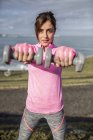 España, Gijón, joven deportiva haciendo ejercicios en la costa - foto de stock