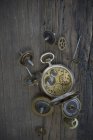 Vecchio orologio da tasca e ruote dentate su legno scuro — Foto stock