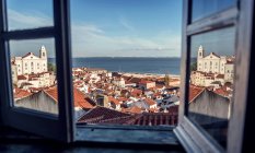 Portugal, Lisbon, view of Alfama neighborhood and River Tejo through open window — Stock Photo