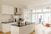Cuisine avec comptoir îlot et table dans l'intérieur du bâtiment moderne — Photo de stock