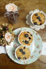 Homemade Cupcakes with blueberries on wood with flowers — Stock Photo