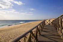 Wooden boardwalk to the sandy beach — Stock Photo