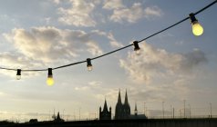 Germany, Colgone, Atmospheric sunset with light bulbs and cathedral — Stock Photo