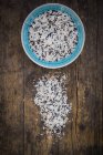 Organic basmati rice in bowl and on dark wood — Stock Photo