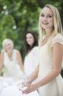 Ritratto di donna bionda sorridente che apparecchiava una tavola all'esterno — Foto stock