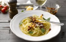 Dish of spaghetti with tomato pesto and grated parmesan — Stock Photo