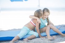 Deux filles heureuses assises sur une lilo sur la plage — Photo de stock