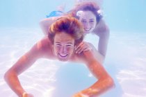South Africa, Capetown, Young couple swimming in pool underwater — Stock Photo