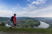Deutschland, rheinland-pfalz, mann wandert mit moselschleife kroev im hintergrund — Stockfoto