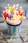 Muffin di compleanno con bottoni di cioccolato e candele accese — Foto stock