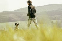 Man with dog on meadow — Stock Photo