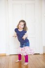 Girl dancing on wooden door at home — Stock Photo