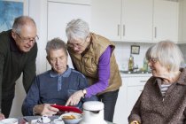 Senior people using digital tablet in kitchen — Stock Photo