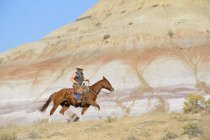 USA, Wyoming, cowboy riding in badlands — Stock Photo