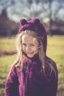 Portrait of smiling litte girl wearing purple hooded jacket — Stock Photo