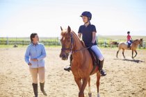 Coach e ragazza a cavallo sul ring di equitazione — Foto stock