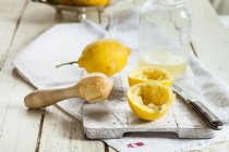 Limones enteros y cortados a la mitad para hacer limonada - foto de stock