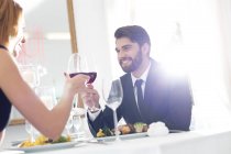 Elegant couple toasting wine glasses in restaurant — Stock Photo
