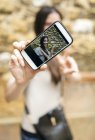 Smartphone avec photo de femme souriante prenant un selfie — Photo de stock