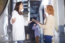 Zwei Frauen diskutieren in Fabrikhalle — Stockfoto