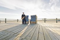 Німеччина, Санкт міського, підлітком зі гітара стоячи перед з капюшоном пляжі кафедри — стокове фото