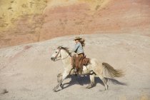 USA, Wyoming, cowgirl riding in badlands — Stock Photo