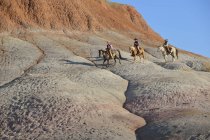États-Unis, Wyoming, cow-girls et un cow-boy chevauchant dans les badlands — Photo de stock