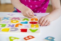 Little girl learning alphabet with wooden letters — Stock Photo