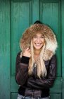Adolescente souriante portant une veste en cuir à capuchon — Photo de stock