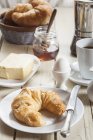 Завтрак с круассаном, яйцом, кофе, медом и маслом — стоковое фото