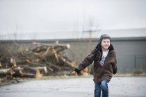 Хлопчик у куртці, що біжить на задньому дворі — стокове фото