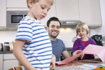 Padre armeggiare in cucina con figlio e figlia — Foto stock