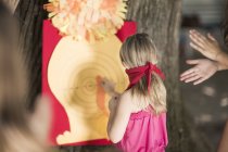 Chicas en el jardín jugando pin la cola en burro - foto de stock