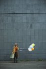 Молодая женщина с чемоданом с шариками — стоковое фото