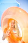 Ragazza sulla spiaggia con uno pneumatico arancione galleggiante — Foto stock