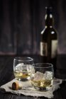 Two tumblers with whisky and ice — Stock Photo