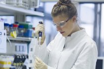 Biólogo trabajando en laboratorio con pipeta - foto de stock
