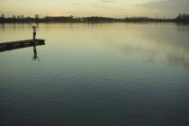 Deutschland, roxheim, frau steht auf hölzerner promenade am wasser — Stockfoto