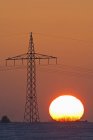 Deutschland, Sonnenuntergang neben Strommasten — Stockfoto