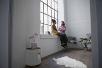 Giovane coppia seduta in appartamento e parlando tra di loro — Foto stock