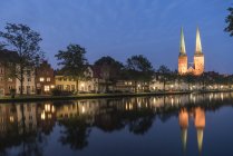 Німеччина, Любек, старий місто подання з ілюстрованих собору та річку Траве в сутінках — стокове фото