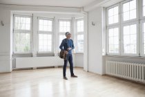 Homem olhando ao redor em apartamento vazio — Fotografia de Stock